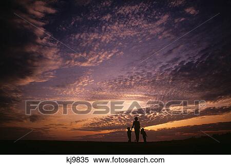 Stock Photography - silhouette mother and children cloudy sky. Fotosearch
