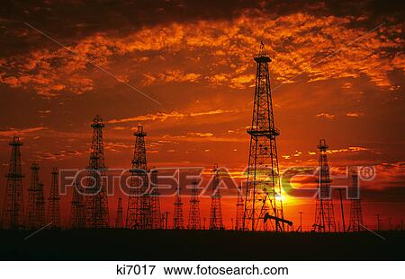 silhouetted oil derricks and pumps at sunset View Large Photo Image Stock Photo - silhouetted oil derricks and pumps at sunset. Fotosearch