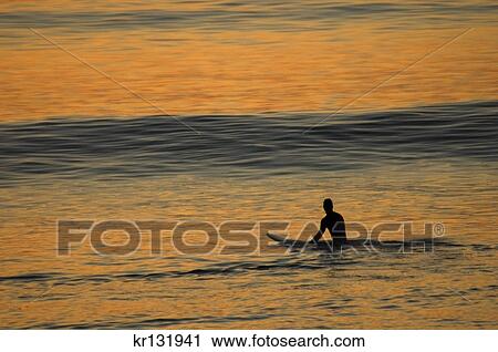 Stock Image - single man on surfboard waiting for wave at sunset cliffs park ocean beach california. Fotosearch