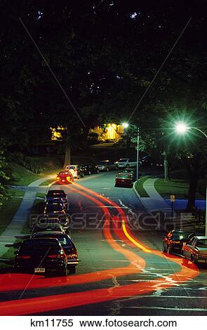 streaks of light from car headlights on residential street at night View Large Photo Image Stock Photography - streaks of light from car headlights on residential street at night. Fotosearch
