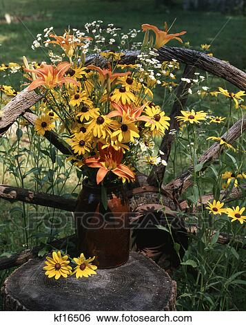 summer wildflower bouquet outdoors on tree stump by wagon wheel View Large Photo Image Stock Photograph - summer wildflower bouquet outdoors on tree stump by wagon wheel. Fotosearch