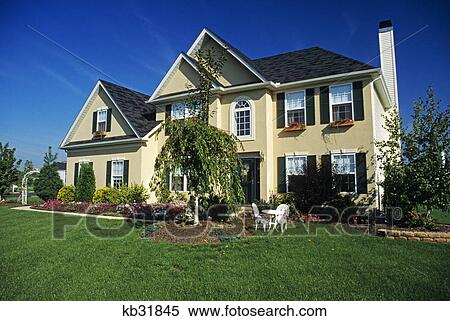 Stock Photography - tan house with landscaped lawn. Fotosearch