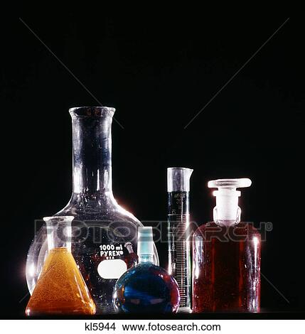 Picture - various sizes of laboratory glass bottles flasks and vials with colorful liquids on black background. Fotosearch