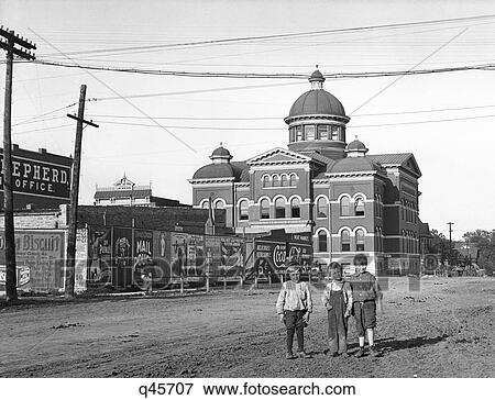 1900S 1910S 3 Boys Middle Of Unpaved Dirt Street Emporia Kansas With Advertising Signs On Fence View Large Photo Image Stock Photo - 1900S 1910S 3 Boys Middle Of Unpaved Dirt Street Emporia Kansas With Advertising Signs On Fence. Fotosearch