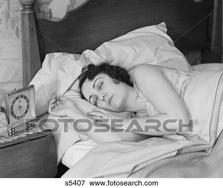 1920S 1930S Brunette Woman Asleep In Bed Alarm Clock On Night Stand Sleeping View Large Photo Image Stock Photo - 1920S 1930S Brunette Woman Asleep In Bed Alarm Clock On Night Stand Sleeping. Fotosearch