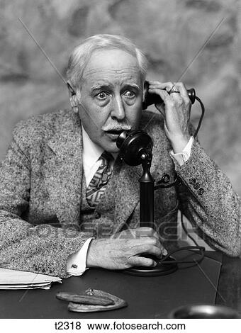 Stock Photo - 1920S 1930S Businessman On Candlestick Telephone Looking Surprised And Alarmed. Fotosearch