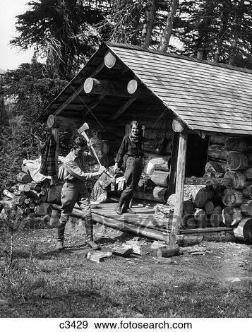 1920S 1930S Couple Woman Standing On Porch Of Log Cabin Holding Pitcher Man Chopping Wood Assiniboine Canada View Large Photo Image Stock Photo - 1920S 1930S Couple Woman Standing On Porch Of Log Cabin Holding Pitcher Man Chopping Wood Assiniboine Canada. Fotosearch