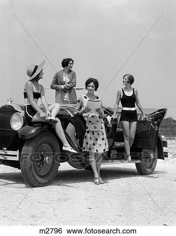1920S 1930S Four Women In Dresses And Bathing Suits Gathered Around Convertible Touring Car At Seashore Beach View Large Photo Image Stock Photograph - 1920S 1930S Four Women In Dresses And Bathing Suits Gathered Around Convertible Touring Car At Seashore Beach. Fotosearch