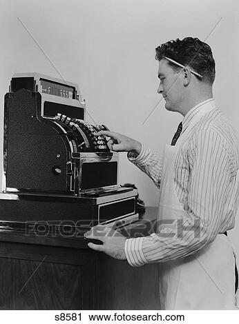 1920S 1930S Man Wearing Apron Ringing Up Sale On Cash Register View Large Photo Image Stock Image - 1920S 1930S Man Wearing Apron Ringing Up Sale On Cash Register. Fotosearch