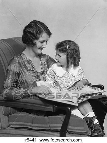 1920S 1930S Mother & Daughter Smiling Sitting In Chair Reading Book