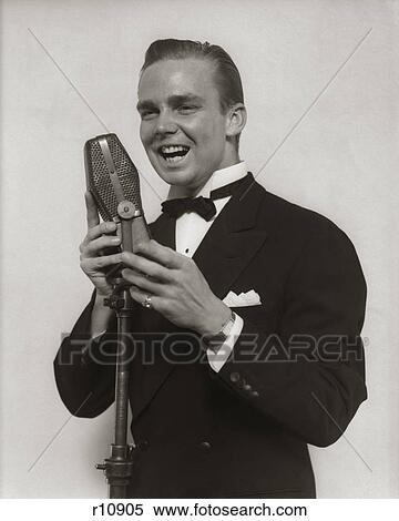 1920S 1930S Smiling Man Radio Singer Entertainer Crooner In Tuxedo Singing Into Microphone View Large Photo Image Stock Photography - 1920S 1930S Smiling Man Radio Singer Entertainer Crooner In Tuxedo Singing Into Microphone. Fotosearch