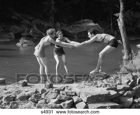 1920S 1930S Two Women Pulling Man Into Woodland Swimming Pond All Wearing Bathing Suits View Large Photo Image Stock Image - 1920S 1930S Two Women Pulling Man Into Woodland Swimming Pond All Wearing Bathing Suits. Fotosearch