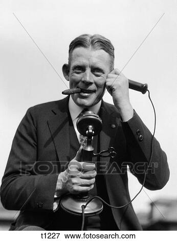 1920S Portrait Of Businessman Talking On Candlestick Phone Smoking Cigar Office Indoor View Large Photo Image Stock Photo - 1920S Portrait Of Businessman Talking On Candlestick Phone Smoking Cigar Office Indoor. Fotosearch