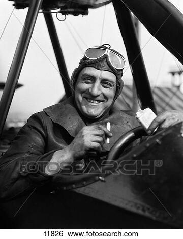 1920S Smiling Man Pilot In Cockpit Of Airplane Looking At Camera Taking Cigarette Out Of Pack View Large Photo Image Stock Photograph - 1920S Smiling Man Pilot In Cockpit Of Airplane Looking At Camera Taking Cigarette Out Of Pack. Fotosearch