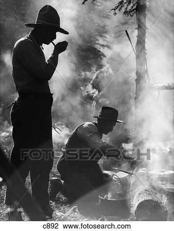 1920S Three Men Cowboys Camping One Man Smoking Pipe One Man Cooking Over Campfire Moody Silhouette View Large Photo Image Stock Image - 1920S Three Men Cowboys Camping One Man Smoking Pipe One Man Cooking Over Campfire Moody Silhouette. Fotosearch
