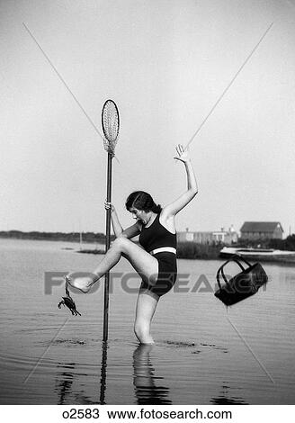 Stock Image - 1920S Woman Crabbing Surprised By Crab Biting Her Toe. Fotosearch
