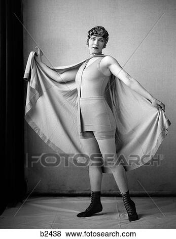 1920S Woman In Old-Fashioned Bathing Suit & Cap Holding Out Large Cape Tied Around Neck Looking At Camera View Large Photo Image Stock Photo - 1920S Woman In Old-Fashioned Bathing Suit & Cap Holding Out Large Cape Tied Around Neck Looking At Camera. Fotosearch
