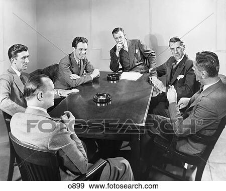 1930S 1940S 6 Businessmen Meeting In Boardroom Around Table With Ashtrays View Large Photo Image Stock Photo - 1930S 1940S 6 Businessmen Meeting In Boardroom Around Table With Ashtrays . Fotosearch