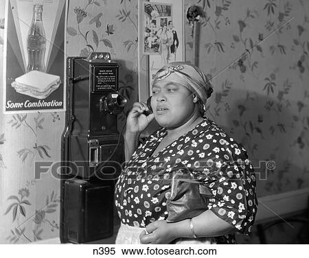 1930S 1940S African American Woman Talking On Public Pay Wall Telephone In Public Restaurant View Large Photo Image Stock Photography - 1930S 1940S African American Woman Talking On Public Pay Wall Telephone In Public Restaurant. Fotosearch