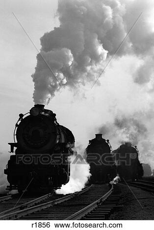 1930S 1940S Head-On View Of Three Steam Engines Silhouetted Against Billowing Smoke And Steam Outdoor View Large Photo Image Stock Photograph - 1930S 1940S Head-On View Of Three Steam Engines Silhouetted Against Billowing Smoke And Steam Outdoor. Fotosearch