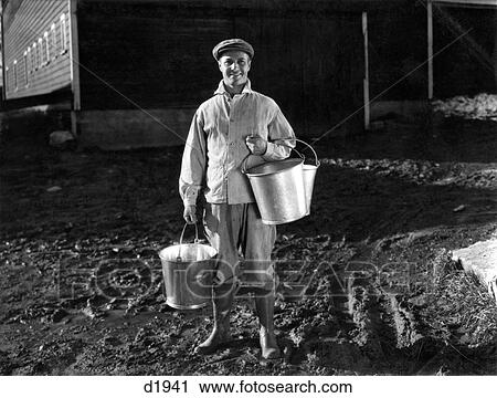 1930S 1940S Man Farmer Dairyman Standing Outside Barn Holding Milk Pails Wearing Cap Jacket Rubber Knee Boots Smiling Looking At Camera View Large Photo Image Stock Image - 1930S 1940S Man Farmer Dairyman Standing Outside Barn Holding Milk Pails Wearing Cap Jacket Rubber Knee Boots Smiling Looking At Camera. Fotosearch