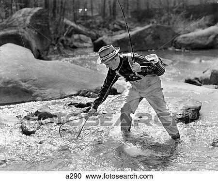 1930S 1940S Man Fly Fishing Wearing Waders Holding Rod And Netting A Successful Catch View Large Photo Image Stock Image - 1930S 1940S Man Fly Fishing Wearing Waders Holding Rod And Netting A Successful Catch. Fotosearch