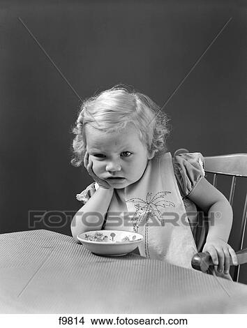 1930S 1940S Sad Baby Girl At Table With Cereal Bowl View Large Photo Image Picture - 1930S 1940S Sad Baby Girl At Table With Cereal Bowl. Fotosearch