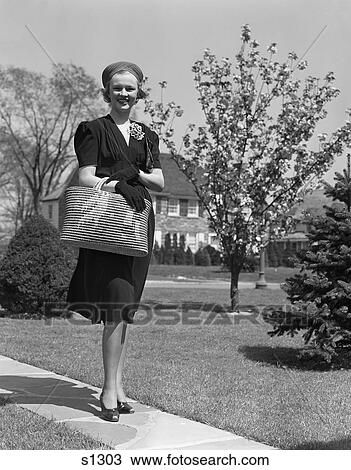 1930S 1940S Stylishly Dressed Woman Walking Down Suburban Street Carrying Straw Bag View Large Photo Image Stock Image - 1930S 1940S Stylishly Dressed Woman Walking Down Suburban Street Carrying Straw Bag . Fotosearch