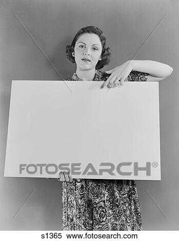 1930S 1940S Woman Holding Blank Poster Sign Hand Pointing From Top Looking At Camera Looking At Camera View Large Photo Image Stock Photography - 1930S 1940S Woman Holding Blank Poster Sign Hand Pointing From Top Looking At Camera Looking At Camera. Fotosearch