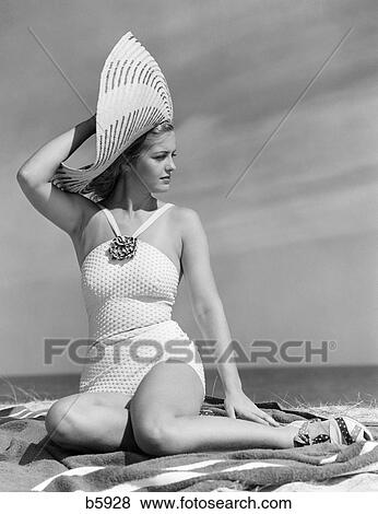 Stock Photo - 1930S 1940S Woman In White Bathing Suit On Beach Wearing Big Straw Hat. Fotosearch