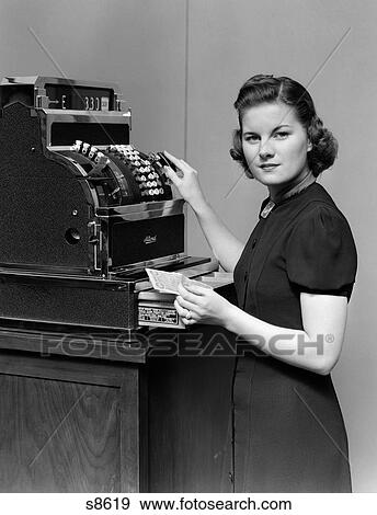 1930S 1940S Woman Sales Clerk Making Change At Cash Register Holding Money Looking At Camera View Large Photo Image Stock Photo - 1930S 1940S Woman Sales Clerk Making Change At Cash Register Holding Money Looking At Camera. Fotosearch