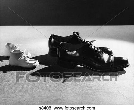 Stock Photo - 1930S Baby Booties Following In Footsteps Of Man'S Shoes. Fotosearch