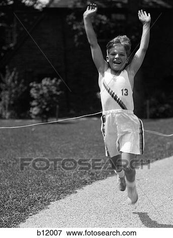 1930S Boy In Track Uniform With Arms In Air Breaking Tape At Finish Line View Large Photo Image Stock Photo - 1930S Boy In Track Uniform With Arms In Air Breaking Tape At Finish Line. Fotosearch