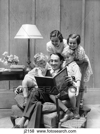 Stock Photo - 1930S Father Reading To Family In Chair. Fotosearch