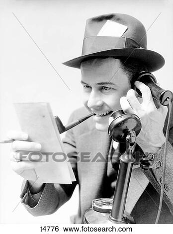 1930S Newspaper Reporter Man Smoking Pipe Talking On Black Upright Phone Excited Press Pass In Hat Reading From Note Pad Reporting Story View Large Photo Image Stock Photograph - 1930S Newspaper Reporter Man Smoking Pipe Talking On Black Upright Phone Excited Press Pass In Hat Reading From Note Pad Reporting Story. Fotosearch