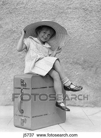 1930S Portrait Smiling Little Girl Sitting On Suitcase Wearing Big Straw Hat View Large Photo Image Stock Photo - 1930S Portrait Smiling Little Girl Sitting On Suitcase Wearing Big Straw Hat. Fotosearch