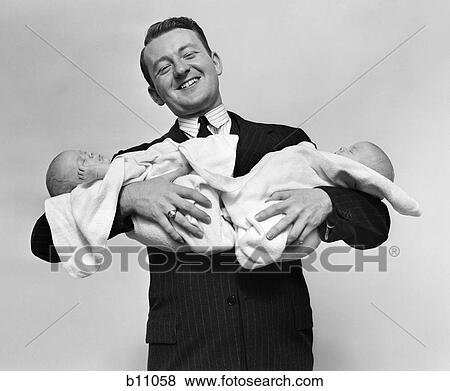 1930S Proud Father Smiling Proudly Holding Twin Babies View Large Photo Image Stock Photo - 1930S Proud Father Smiling Proudly Holding Twin Babies. Fotosearch