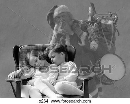 Picture - 1930S Santa Claus Finger To Lips Sack Of Christmas Toy Presents Over Shoulder Ghost Behind Boy And Girl Asleep In Chair. Fotosearch