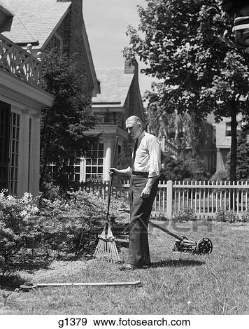 Stock Photo - 1930S Senior Man Standing By Garden Shrubs With Rake Push Mower Lawnmower Behind Him. Fotosearch