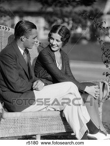 1930S Smiling Couple Sitting Together On Wicker Bench Husband Wife Outdoor View Large Photo Image Stock Image - 1930S Smiling Couple Sitting Together On Wicker Bench Husband Wife Outdoor. Fotosearch