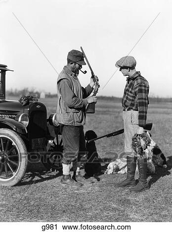 1930S Two Men Hunters By Car Looking At Shotgun With Dogs And Brace Of Birds View Large Photo Image Stock Image - 1930S Two Men Hunters By Car Looking At Shotgun With Dogs And Brace Of Birds. Fotosearch