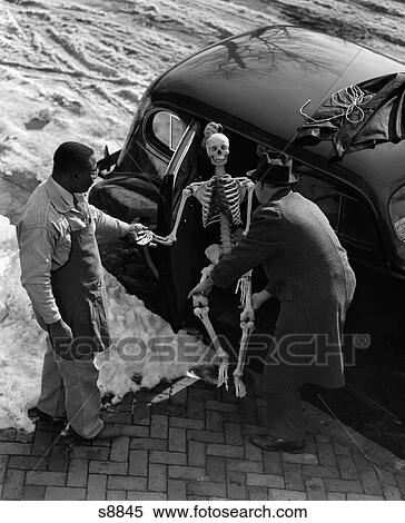 1930S Two Men Taking Skeleton Out Of Back Seat Of Car Outdoor Winter View Large Photo Image Stock Photography - 1930S Two Men Taking Skeleton Out Of Back Seat Of Car Outdoor Winter. Fotosearch