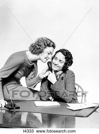1930S Two Smiling Office Workers Women Talking Into Receptionists Telephone Set Sitting At Desk Headphones Microphone Business Office View Large Photo Image Stock Image - 1930S Two Smiling Office Workers Women Talking Into Receptionists Telephone Set Sitting At Desk Headphones Microphone Business Office. Fotosearch