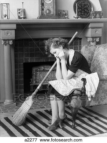 1930S Unhappy Woman Sitting On Chair Head Down In Front Of Fireplace Wearing Apron With A Broom At Her Side View Large Photo Image Stock Photo - 1930S Unhappy Woman Sitting On Chair Head Down In Front Of Fireplace Wearing Apron With A Broom At Her Side. Fotosearch
