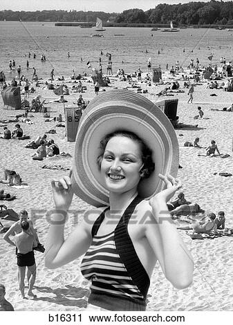 1930S Vacation Montage Portrait Smiling Woman In Bathing Suit Wearing Large Straw Hat And Scene Of Crowded Beach View Large Photo Image Stock Image - 1930S Vacation Montage Portrait Smiling Woman In Bathing Suit Wearing Large Straw Hat And Scene Of Crowded Beach. Fotosearch