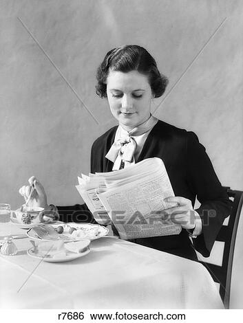 Stock Photograph - 1930S Woman Reading Newspaper Eating Breakfast. Fotosearch