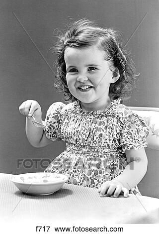 Stock Photo - 1940S 1930S Smiling Little Girl Eating Bowl Of Ice Cream. Fotosearch