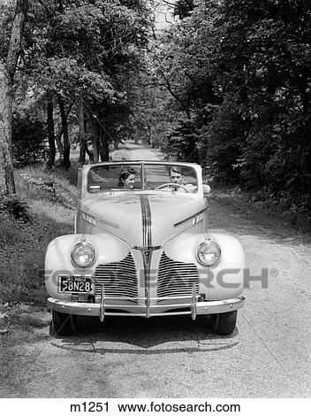 1940S 1941 Couple Man And Woman In Pontiac Convertible Driving On Country Lane In Countryside View Large Photo Image Stock Image - 1940S 1941 Couple Man And Woman In Pontiac Convertible Driving On Country Lane In Countryside. Fotosearch