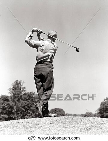 1940S 1950S Man Playing Golf Teeing Off Swinging Driver Club View Large Photo Image Stock Photo - 1940S 1950S Man Playing Golf Teeing Off Swinging Driver Club. Fotosearch