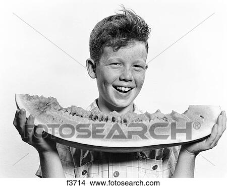 Picture - 1940S 1950S Smiling Boy Holding Eating Large Slice Of Watermelon. Fotosearch